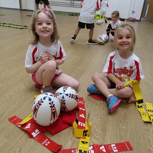 Children sitting in a circle at a Rugby Stars session