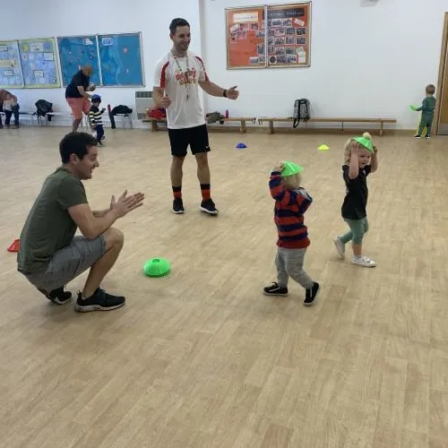 Coach leading a fun game with toddlers